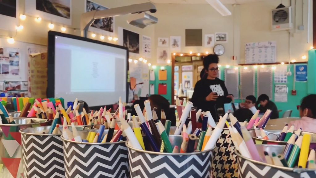 art supplies in foreground with workshop happening in background