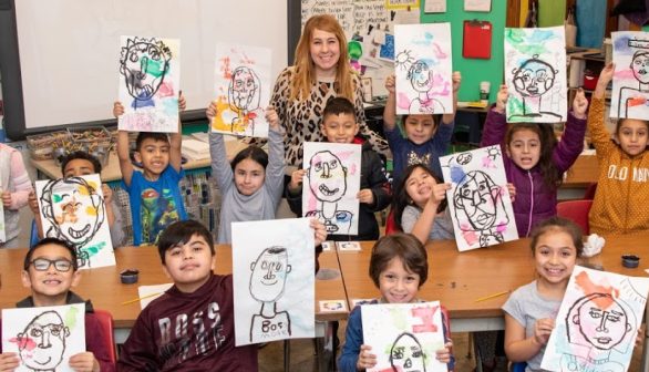 students holding up artwork small