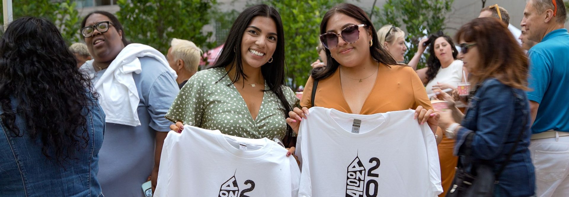 two latinas hold up their t shirts at ipmm event, copyright by ipaintmymind